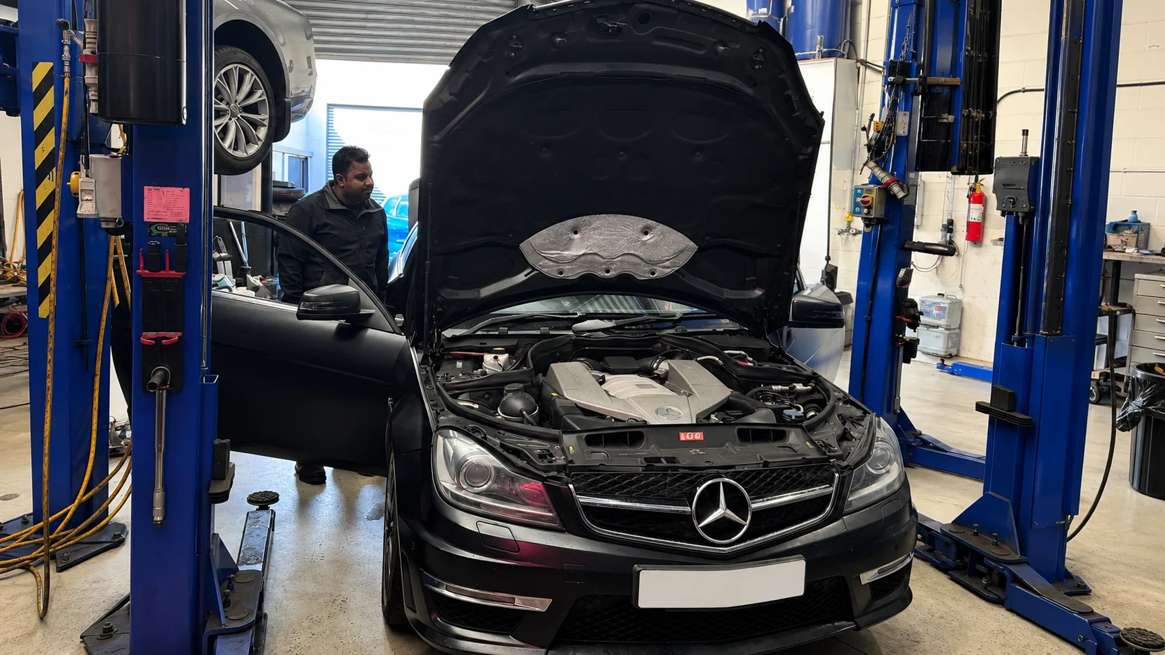 PSM Workshop mechanic inspecting the engine of a Mercedes during mechanical repair work